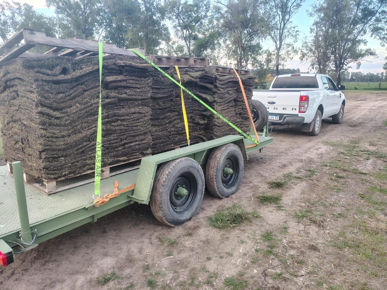 Acoplado con pallets de pasto listos para entregar